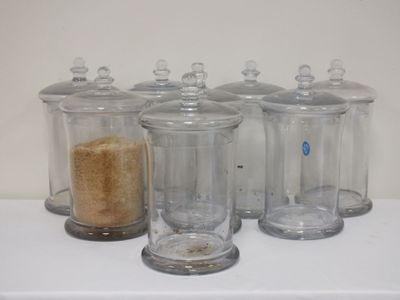 quatre bocaux en verre posés sur une étagère, contenant chacun un biscuit