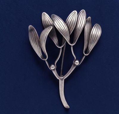 une image représentant une broche en argent ornée de fleurs sur fond bleu