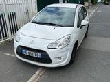 la petite voiture blanche est garée sur le bord de la route