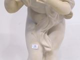 a small statue of a boy holding something in his hands