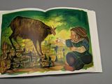 an open book with a picture of a girl and a goat