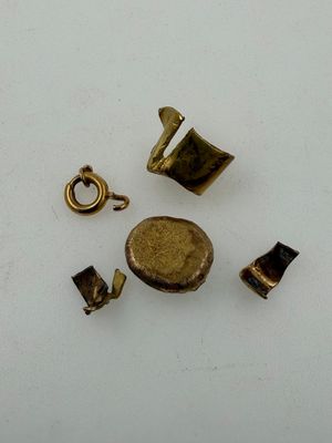 several pieces of brass are arranged in a circle on a white surface