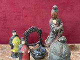 trois figurines posées sur une table, avec un mur rouge en arrière-plan