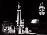 une photo en noir et blanc représentant une fontaine et une tour horloge