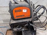 une machine orange et noire posée sur un sol en béton