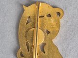 a gold brooch with a bear and a heart on it