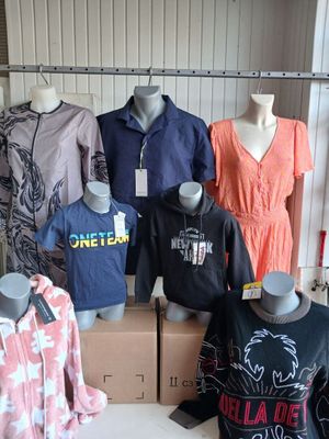 several mannequins and shirts on display in a clothing store