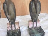 two statues of birds sitting on top of each other