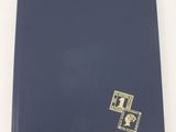 un gros plan d'un livre posé sur une surface blanche, avec une couverture bleue