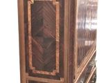 a tall wooden cabinet with a glass door on top