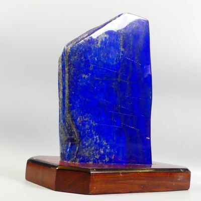 a blue stone on a wooden base on a white background