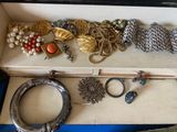 a box filled with assorted jewelry on a blue table