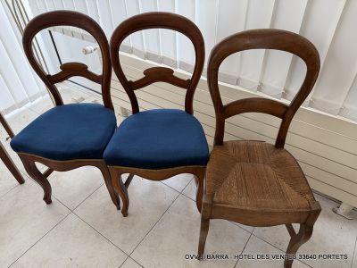 three wooden chairs with blue cushions sit in front of a window