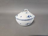 a blue and white bowl with a lid on a table