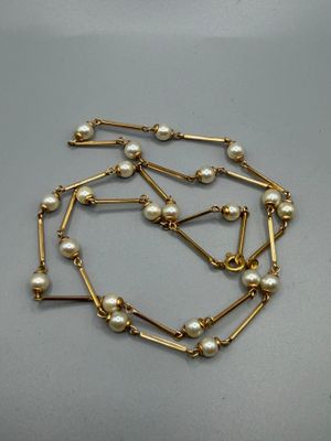 a close up of a necklace with pearls on it
