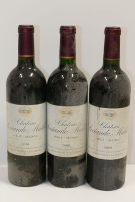 trois bouteilles de vin posées sur une table blanche