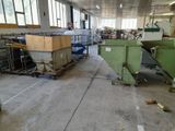 a man standing in a factory with a machine in the background