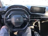 someone is sitting in the driver ' s seat of a car with their feet on the steering wheel