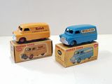 trois petites voitures posées sur des cartons, sur une table