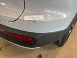 the rear end of a silver car with a sticker on it ' s bumper