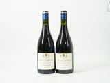 deux bouteilles de vin rouge posées sur une table blanche