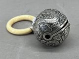 une boule en argent munie d'un anneau, posée sur une table