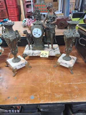 une table sur laquelle se trouvent plusieurs statues et une horloge