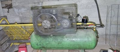un compresseur d'air vert posé sur une table dans une pièce