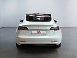 the back of a white tesla model s parked in a room