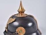 an old helmet with a gold decoration on the top of it