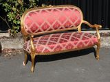 a red and gold couch sitting in the middle of a parking lot