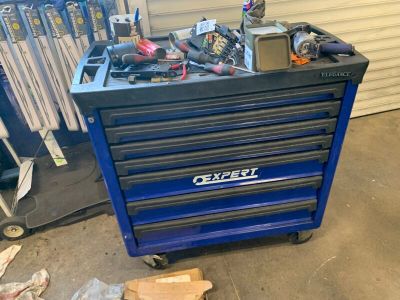 un chariot à outils bleu contenant des outils, dans un garage