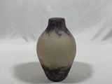a brown and white vase sitting on a white surface