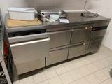 une grande cuisine en inox équipée d'un lave-vaisselle et d'un évier