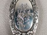 an antique silver spoon with a picture of a woman on it