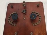 une boîte en bois ornée de boutons, posée sur une surface blanche