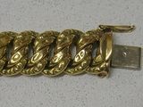un bracelet en or muni d'une chaîne, posé sur une table