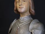 a statue of a man dressed in armor on a black background