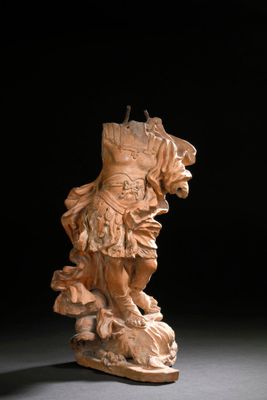 statue d'un homme à cheval, assis sur un rocher dans une pièce sombre