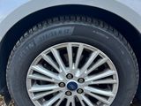 a close up of a car ' s tire on a gravel road