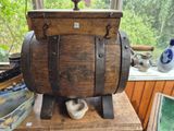 a wooden barrel on a table with a pipe on it