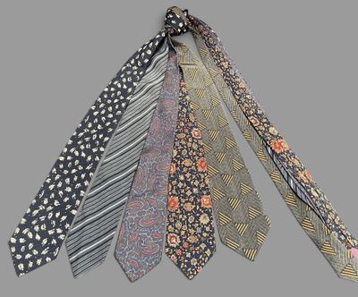 five ties that are tied together on a gray background