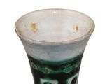 a green and white vase with a face painted on it
