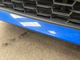 a close up of a blue car ' s grille and front bumper