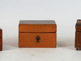 three small wooden boxes sitting next to each other on a white surface