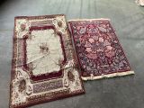 two rugs on the floor in a room next to each other