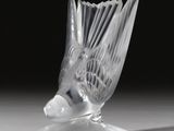 un vase en verre avec un oiseau sur une table