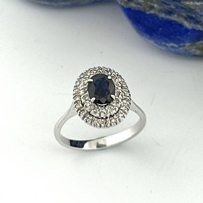 a close up of a ring with a black diamond surrounded by white diamonds