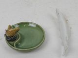 a small bird sitting on a plate next to a feather