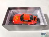 a red toy car in a box on a table